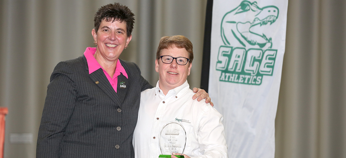 Director of Athletics Sandy Augstein-Collins surprises Dr. Kim Frederick with Fan of the Year Award!