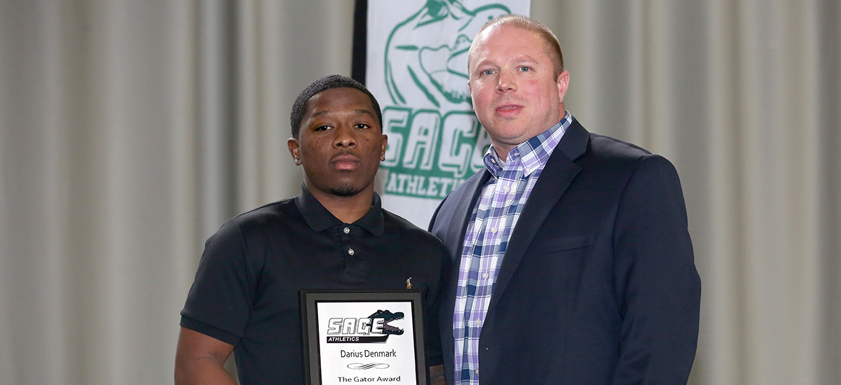 Darius Denmark honored as Gator of the Year in men's basketball as he is given the award from head coach Brian Barnes
